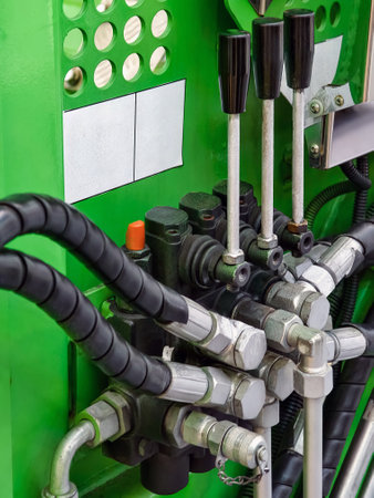 Hydraulic system components displayed in a green machine with various pipes and controls in a workshop settingの写真素材