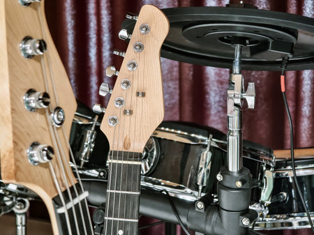 Musical instruments setup with electric guitar and electronic drums in a cozy indoor space during daytimeの写真素材