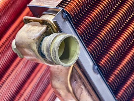 Close-up of industrial heat exchanger with copper fins and brass fittings in a factory setting during daytimeの写真素材