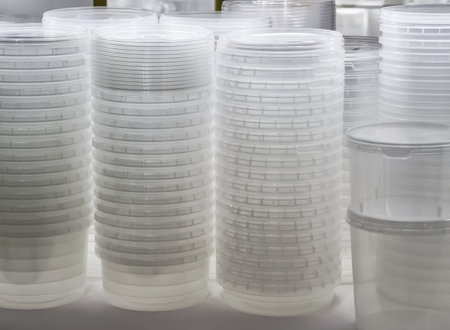 Transparent containers arranged in stacks on a table in a well-lit areaの写真素材