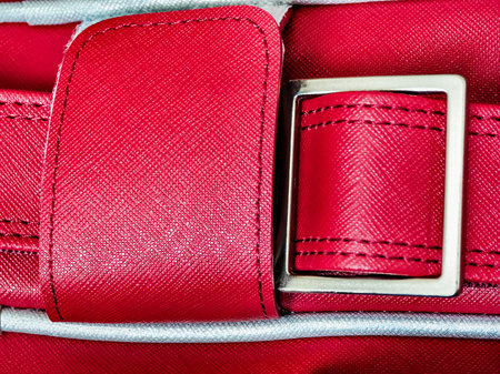 Bright red handbag with a silver buckle showcased in a detailed close-up viewの写真素材