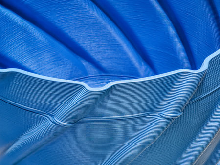 Advanced 3D printing technology creates detailed layers of a blue object in a manufacturing settingの写真素材