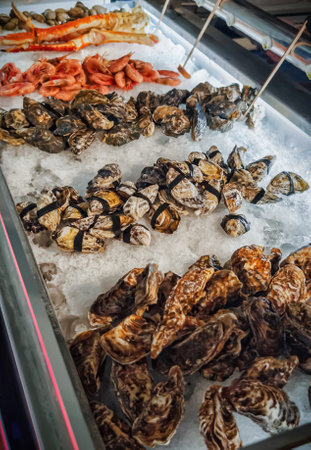 Seafood display with fresh oysters, shrimp, and crab at a market during the dayの写真素材