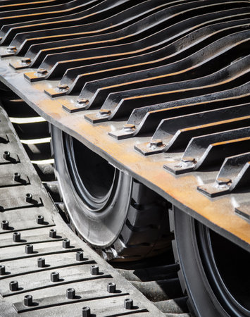 Heavy machinery tracks and wheels in motion during construction work at a building siteの写真素材