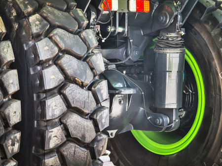Close-up view of a rugged truck tire showcasing intricate details and vibrant green highlights during daylightの写真素材