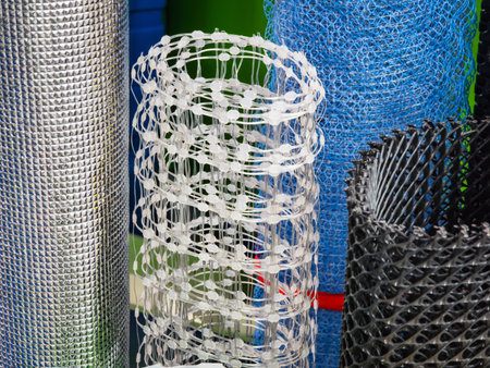 Various types of mesh rolls displayed in a hardware store during daylight hoursの写真素材