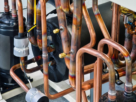 Complex arrangement of copper pipes in industrial cooling system displayedの写真素材