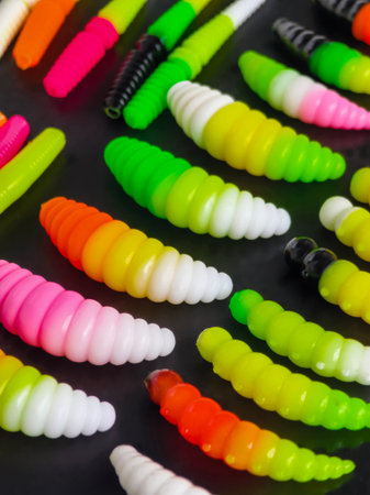 Colorful fishing lures arranged neatly on a dark surface for easy selection and use while anglingの写真素材
