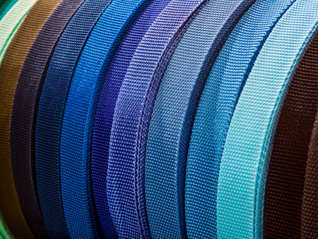 Colorful collection of fabric straps displayed in various shades arranged neatly for textile...