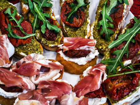 Bruschetta with sun-dried tomatoes, pesto greens and lettuce leaves on toasted slices of breadの写真素材