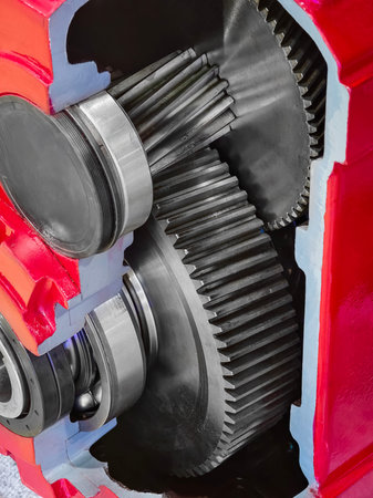 Close view of mechanical gears inside a red engine casing during assembly in a workshop setting
