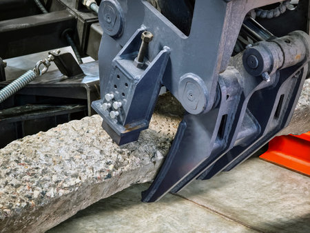 Heavy machinery lifts block during construction work at a job site in the afternoon