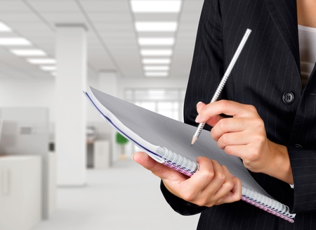 Businesswoman holding pencil and note pad