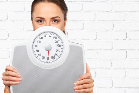 Woman holding measuring scale diet conceptの写真素材