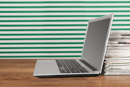 Laptop and Newspapers.の写真素材