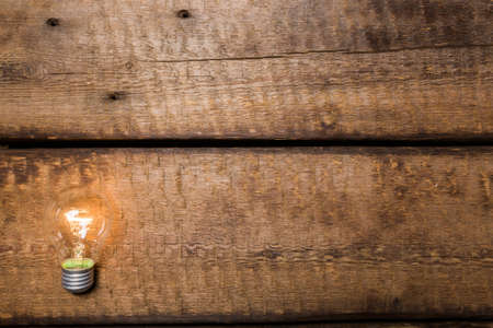 Light bulb on wooden table の写真素材