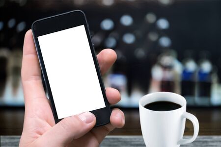 Man holding phone in cafe.