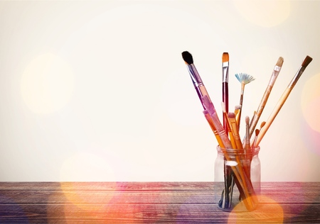 Brushes in glass jar isolated on table
