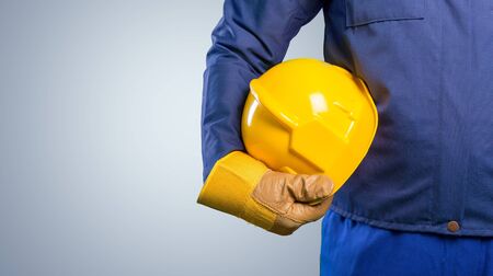 hand of worker with yellow hard-hat,natural lightの写真素材