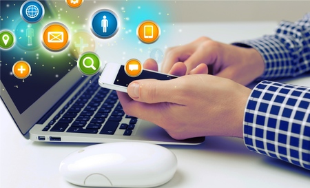 Man hand working on smartphone with computer background. Technology.
