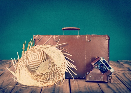 Concept of summer travelling with old suitcase and accessories. Blur beach on backgroundの写真素材