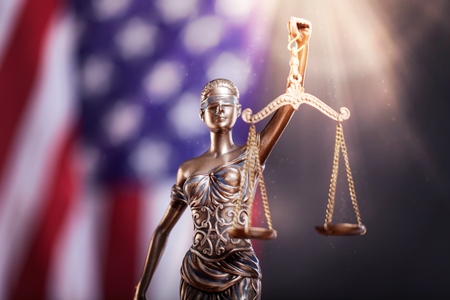 Statue of justice on flag background.の写真素材