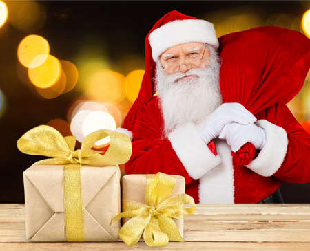 Portrait of happy Santa Claus holding Christmas letter and looking at cameraの写真素材