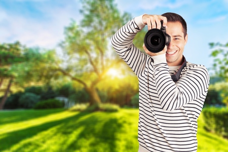 Young photographer taking pictures with digital cameraの写真素材