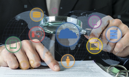 Businessman Looking At Document Through Magnifying Glass