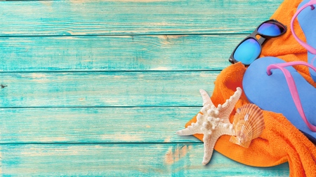 Coconut and beach accessories on blue wooden floor. Top view