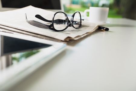 Newspaper with tablet on tableの写真素材