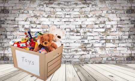 A box full of toys and sports equipment for a holiday charity drive. Isolated on white with reflection.の写真素材