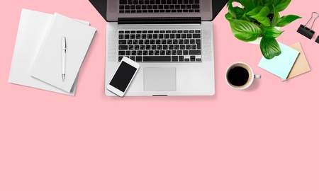 Modern workplace with notebook, coffee cup, tree, smartphone and pencil copy space on color background. Top view. Flat lay style.の写真素材