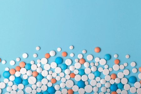 Heap of medicine tablets and pills different colors on white background. Copy space. Healthcare or medicament addiction concept. Empty space for textの写真素材