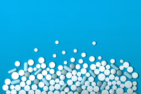Heap of medicine tablets and pills different colors on white background. Copy space. Healthcare or...