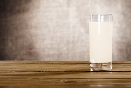 Glass of fresh milk on wooden tableの写真素材