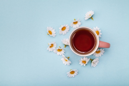 Morning Cup of coffee and a beautiful roses flowers on light background, top view. Cozy Breakfast. Flat lay style.の写真素材