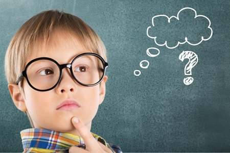 Thinking child with a blackboard in the backgroundの写真素材