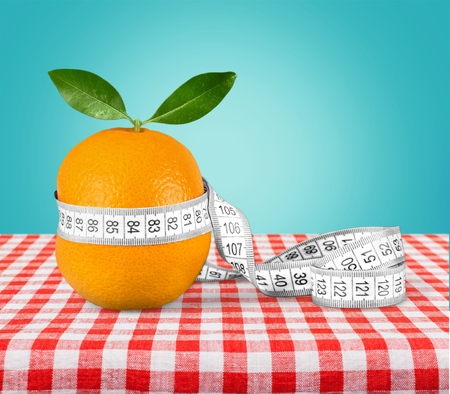 Fresh orange with measuring tape on  tableの写真素材