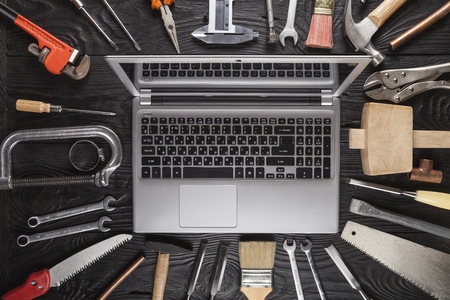 Laptop on a work table with DIY and construction tools all around, top view, hobby and crafts conceptの写真素材