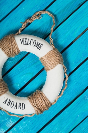 We are hiring ! - Welcome on Board - Lifebuoy with fishnet and blue text on wooden background