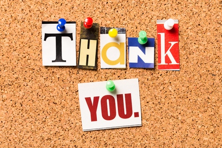 Thank you from cutout newspaper headlines pinned to a cork bulletin boardの写真素材