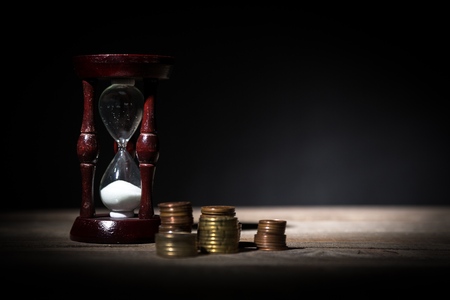 Deadline and time is money concept with hourglass and British coin currencyの写真素材