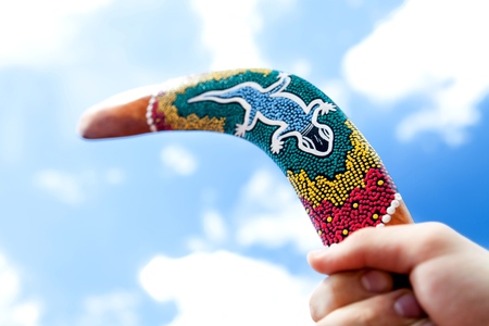Wooden Boomerang with Blue Sky and Cloud Backgroundの写真素材