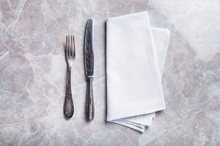 Blank white restaurant napkin mockup with knife and fork, isolated. Cutlery near clear textile towel mock up template. Cafe brand identity overlay surface for   design.の写真素材