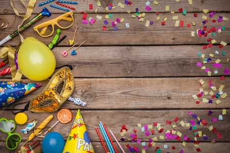 Colorful birthday or carnival frame with party items on wooden backgroundの写真素材