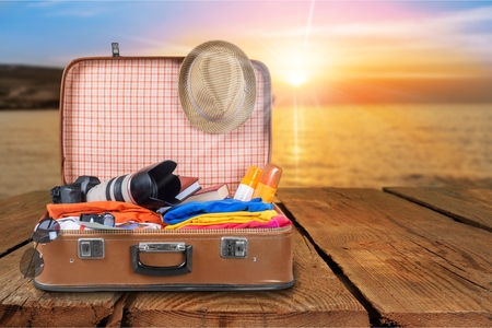 Travel bag with clothes and colorful planes flying out on grungy backgroundの写真素材