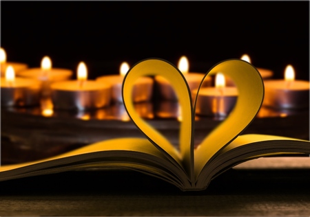 Heart from a book page against a beautiful sunset.