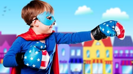 Superhero kid against dramatic blue sky backgroundの写真素材
