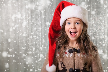 happy child girl in a Christmas hat waiting for a miracle